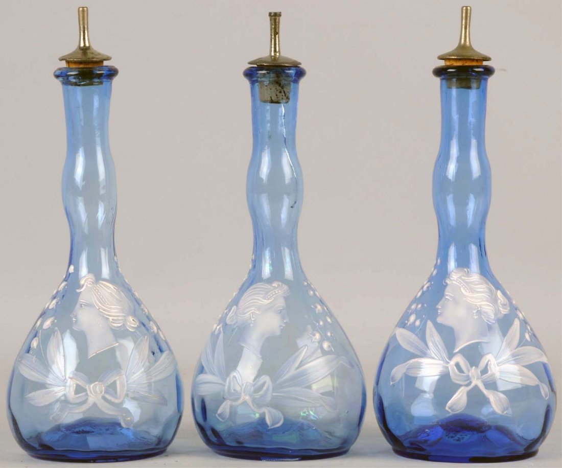 Lot of 3: Light Blue Cameo Head Barber Bottles.: Two of the cameo heads face left and one faces right. No chips or repairs. Middle bottle has crack from top and is about 3" long. Can be seen in photo. All have scarred pontils on the bottom. Conditio