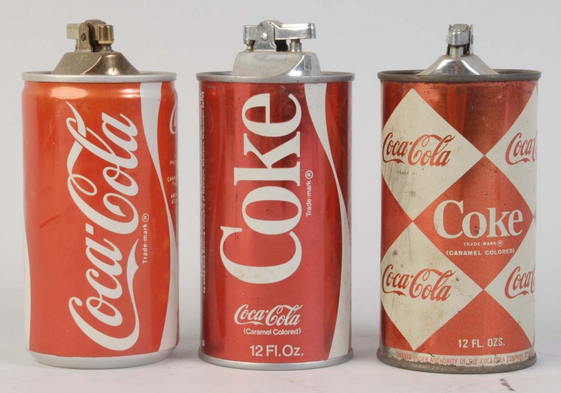 Lot of 3: Coca-Cola Can Cigarette Lighters.: 1950s - 80s. With moderate overall wear. Condition (Very Good). Size Each: 5 - 1/2" T.