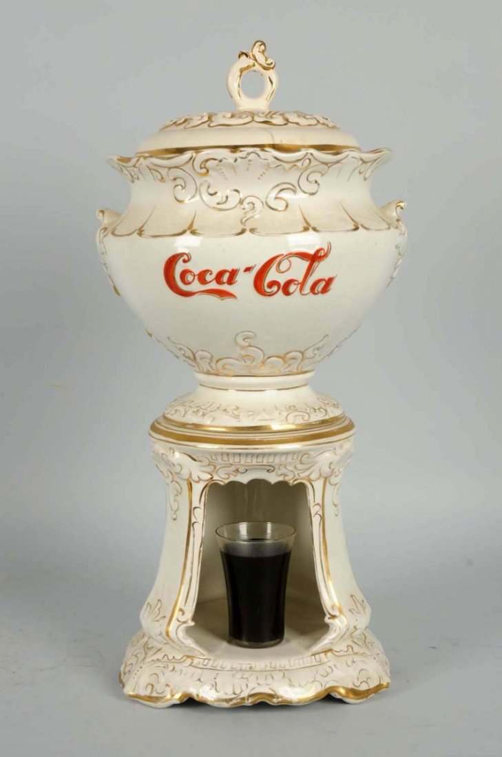 Circa 1900 Coca-Cola Ceramic Urn Dispenser.: Missing the spigot. The lid is a reproduction but displays well. The bowl is original and marked “Wheeling pottery”. Has strong reds and golds remaining with some light rubbing and normal crazing.