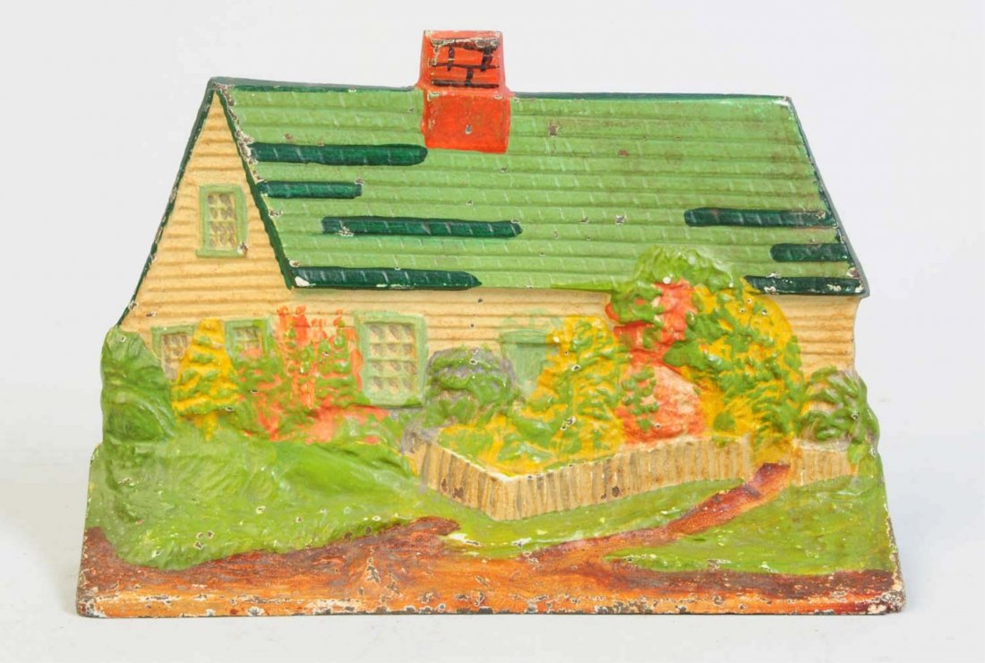 Cast Iron Cottage Doorstop.: Signed and numbered, "Eastern Specialty Mfg. Co., 14". Depicts cottage with picket fence, both adorned in flowers. Condition (Excellent). Size 8 1/2" L.