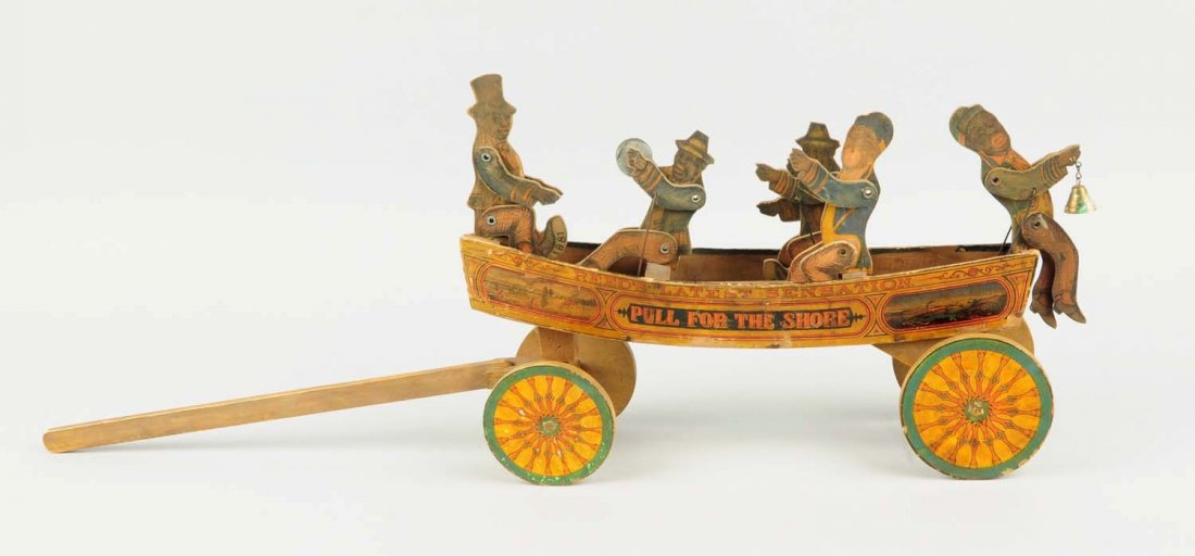 Reed Paper on Wood Boat Toy.: Depicts five African Americans in wood and paper litho boat marked Reed's Latest Sensation Pull for the Shore. Figure on one end is holding a bell and figure on front is directing three men. One holdi