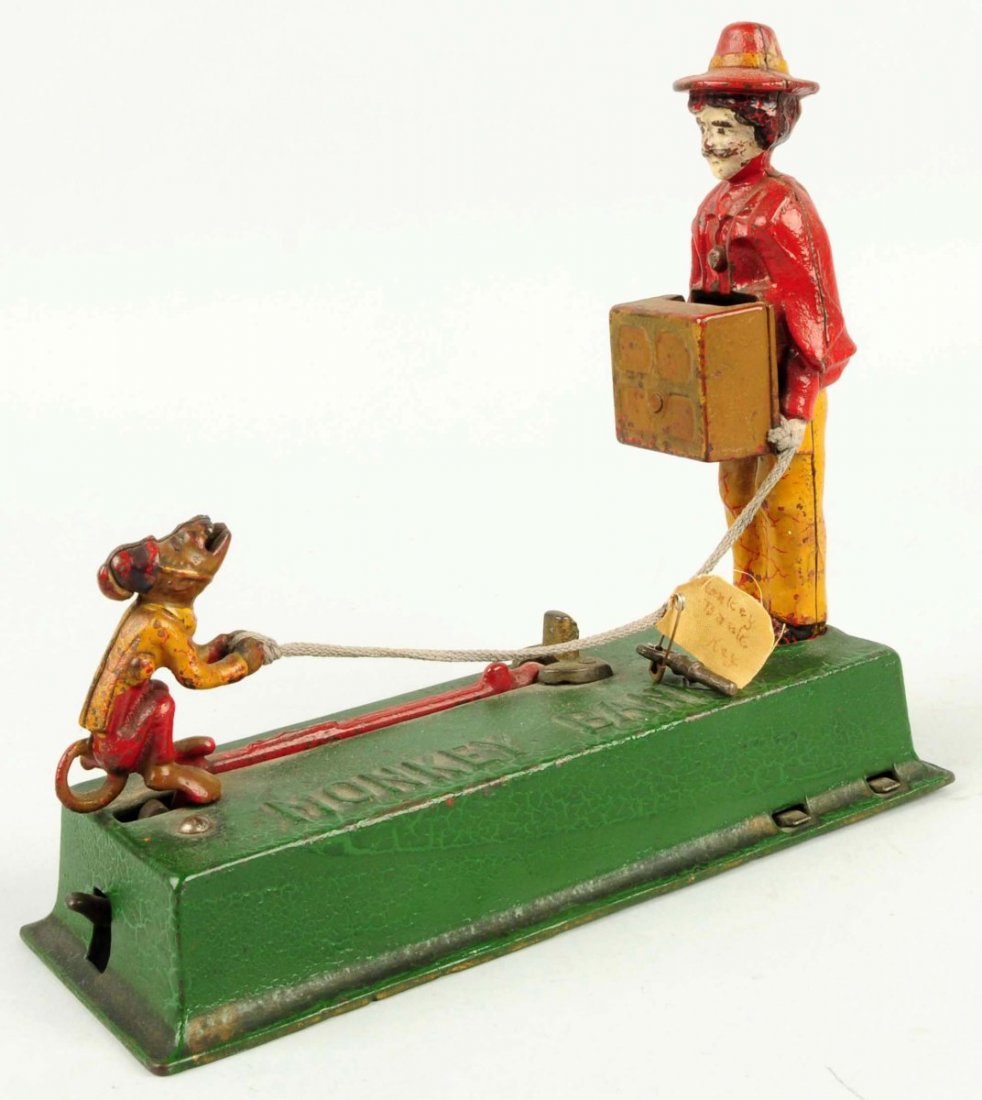 Cast Iron Hubley Monkey Mechanical Bank.: Depicts a man holding organ grinder and operating monkey. Does have key. Some crazing to paint especially to base. An event amount of chipping and wear throughout. Condition (Very Good). Size 8 - 3/4"