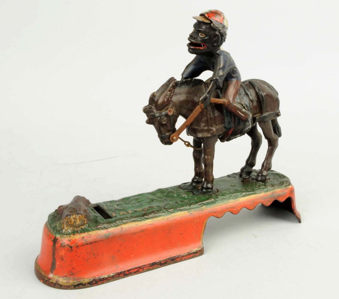 Cast Iron 'Spise a Mule" Mechanical Bank: Red base J & E Stevens Co., Designed by James H. Bowen, Patented 4/22/1879. "The mule and rider being brought into position, a slight touch on a knob at the base causes the mule to kick and throw the 