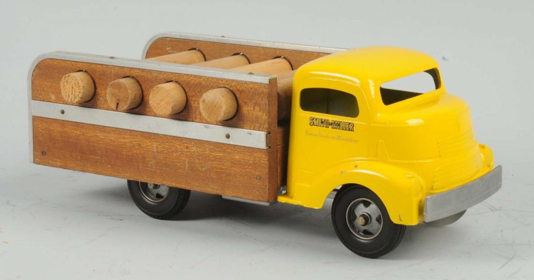 Pressed Steel Smith-Miller Log Truck.: Includes four wooden logs and two wooden barrels in rear. Cab front looks restored. Chuck could be a fantasy piece. Condition (Very Good - Excellent). Size 14" L.