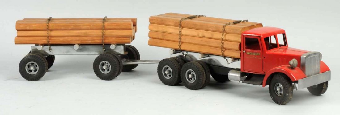 Pressed Steel Smith-Miller Tandem Lumber Truck.: Opening doors, nice decals on sides. Original headlights. Looks to have original wooden load. Has back connecting tandem piece. Some paint chipping and wear to front hood. Condition (Very Good - Excel
