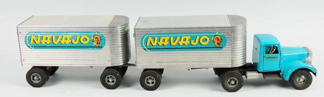 Pressed Steel Smith-Miller Navajo Truck.: Tandem tractor trailer truck. Opening front doors on cab. Unusual turquoise coloring. Front cab has some rubbing and looks to have been restored. Back tandems are original with Navajo Indian decals on