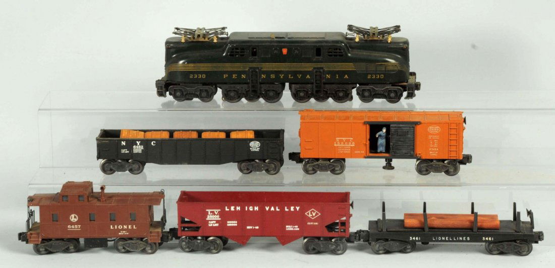 Lionel O Gauge No.2330 GG-1 Freight Train Set.: Post war. Includes No.2330 double motor five stripe Pennsylvania GG-1 engine with original pantographs. Some rubbing to the striping on one side. Also includes four freight cars and a No.6457 smoking