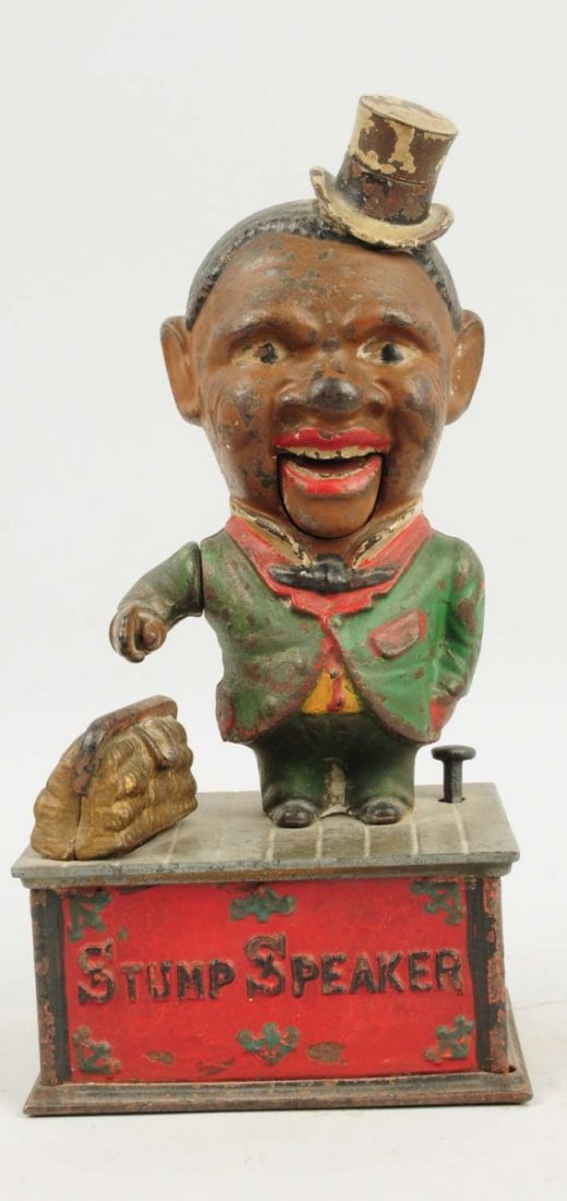 Cast Iron Stump Speaker Mechanical Bank.: This stump speaker bank has moderate paint loss but is in good working order. Trap has been replaced. Condition (Very Good). Size 10" T.