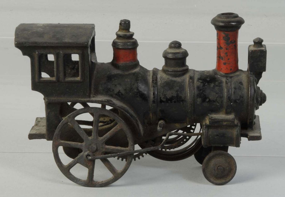Early American Made Clockwork Train Engine.: American style. Cow catcher on front is broken and missing. Engine is embossed with "Patent-Pending" on both sides of cab. Three stacks. Has cast iron wheels with one wheel being broken. Some paint lo