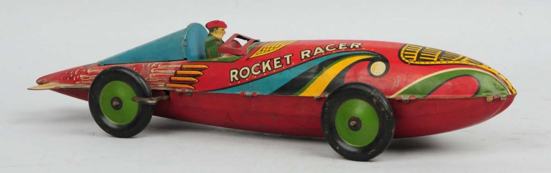 Marx Tin Litho Wind Up Rocket Racer Car.: Original driver. Marked "Rocket Racer" on both sides of car. Missing front rubber bumper. Some scratching and wear. Condition (Very Good). Size 17 - 5/8"L.