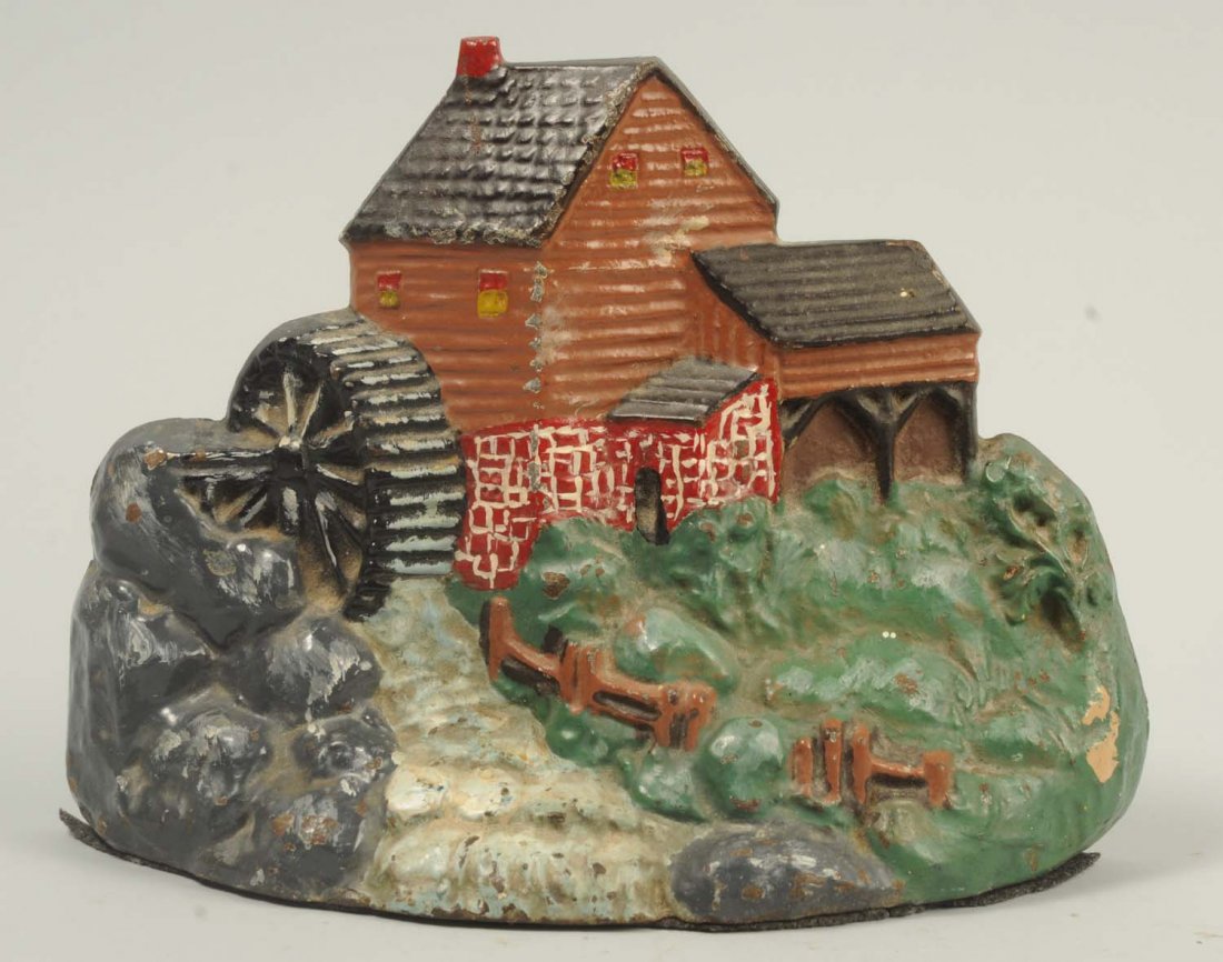 Cast Iron Mill Doorstop.: By “Crenier Novelties, No. 6”. Depicts stream running from water wheel beside stone foundation of mill with clap board siding. Rare. Condition (Excellent Plus). Size 6 - 1/4" T.