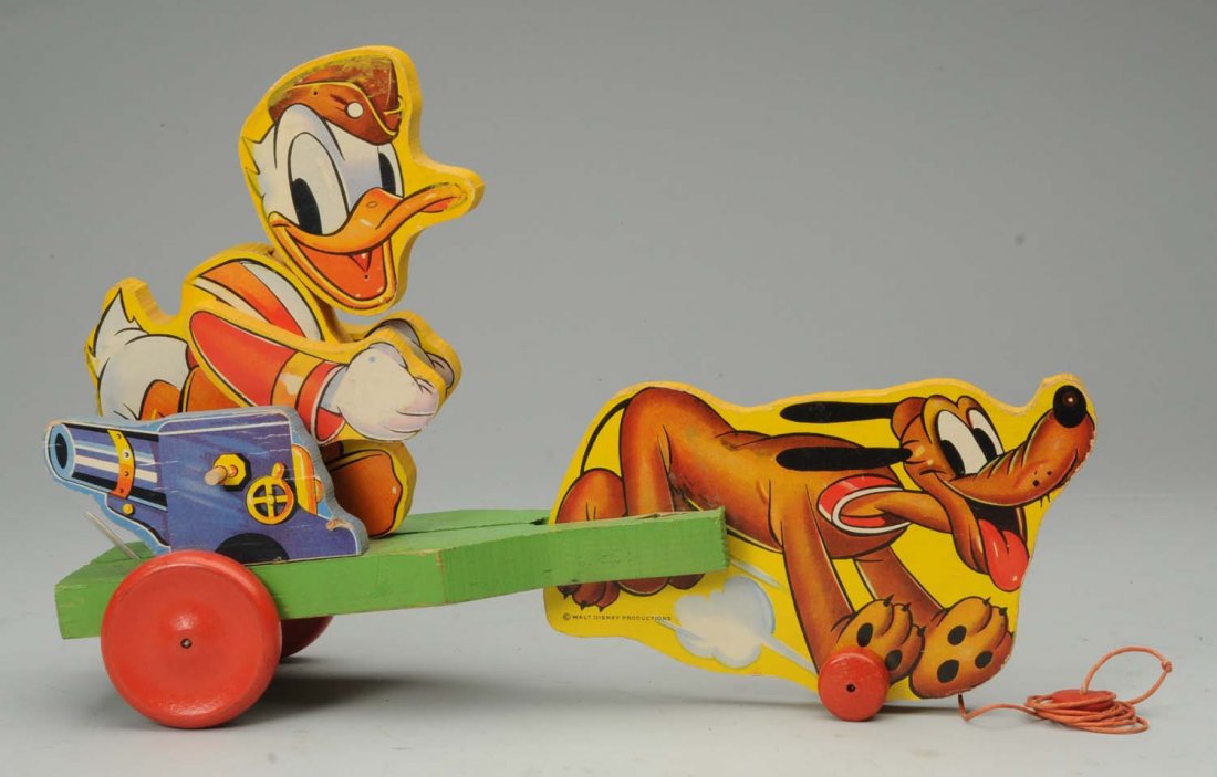 Fisher-Price Doughboy Donald Toy: Circa 1932. Paper on wood. Marked 'Walt Disney Productions'. Toy has good motion. Some general edge wear and remnants of old yellow paint around one side of Donald's head. Condition (Very Good - Excel