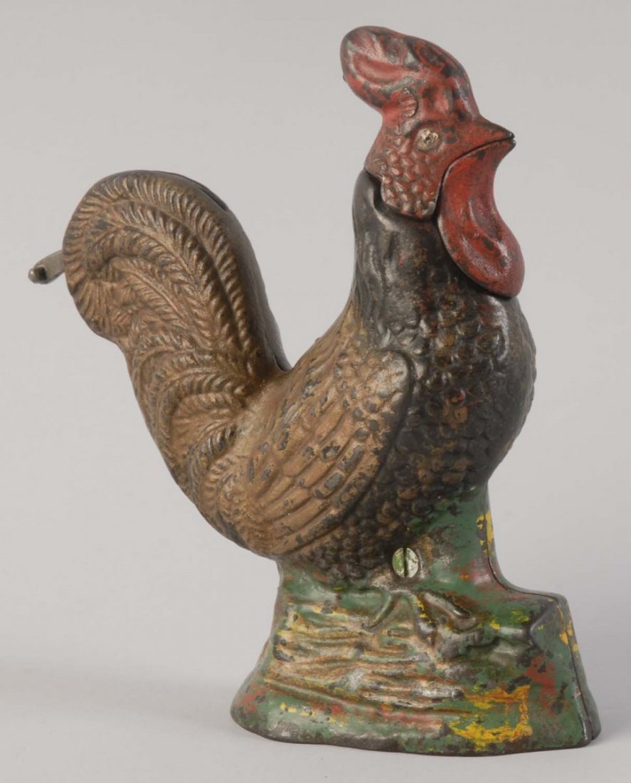 Rooster Mechanical Bank.: Manufactured by Kyser & Rex. It is not working properly. The rooster is painted in light and dark brown, red, and green colors. Overall it is a very well preserved toy. Condition (Excellent). Size 6 -