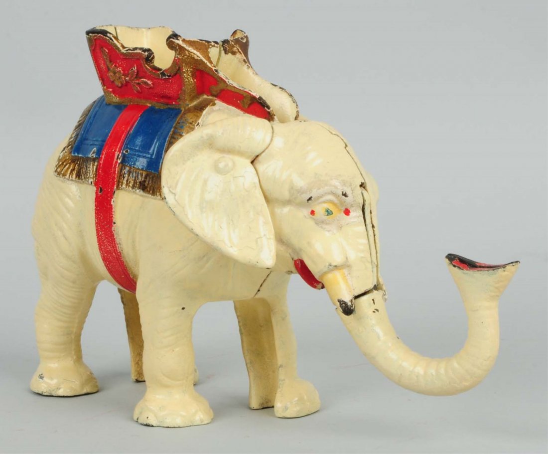 Cast Iron Elephant Bank.: The toy is the one with the pull tail. It is an early repaint and has more colors such as red, blue, tan, and brown. When the tail is pulled out, the trunk goes up and deposits a penny into the elepha