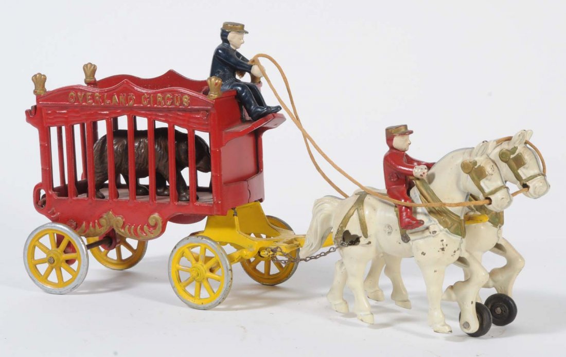 Cast Iron Circus Wagon with Horse.: Includes the driver, a horse rider, two horses, and a bear. The whole set has minor scratches throughout. Otherwise, it is painted in bright red, blue, yellow, and white colors. The wagon is embossed 