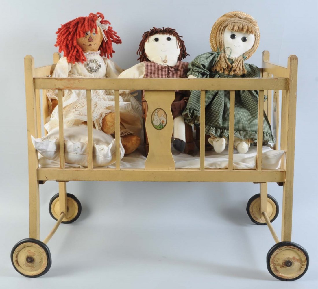 Lot of 3: Cloth Dolls in a Vintage Wooden Cradle.: Cradle is on wheels with decal. Cradle size: 22" T. Condition (Good).