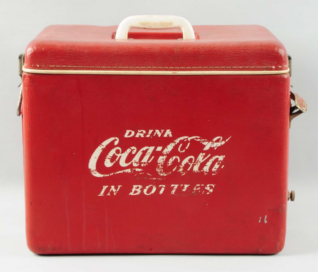 Red Vinyl Coca-Cola Cooler.: This red vinyl Coca-Cola cooler has moderate overall wear. There are several holes punched in the vinyl. Some loss to the white lettering. Condition (Very Good). Size 14" T.
