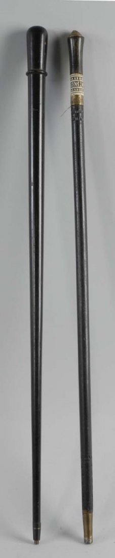 Lot of 2: Black Canes.: The first cane in the lot has a carved bone and brass handled sword cane from India circa 1900. The second is a flask cane with a glass liquor tube and cork stopper circa 1880. The handle unscrews. Th