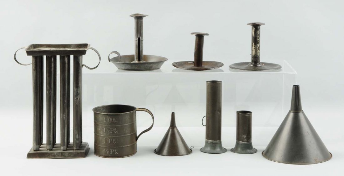 Lot of 8: Tinware Pieces.: This lot includes a candle mold, two candlesticks, two funnels, a measuring cup, and several other items. Condition (Very Good). Size Largest : 10 -1/2" L.