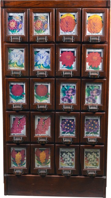 Early F.F. Smith & Co. 20-Drawer Seed Filing Cabinet.: Early F.F. Smith & Co. Inc. 20-Drawer Wood Floor Seed Filing Cabinet w/ glass display front drawers w/ picture labels on each drawer (Marigold, Sweet Pea, etc.), Copper flash on metal handles 30” x