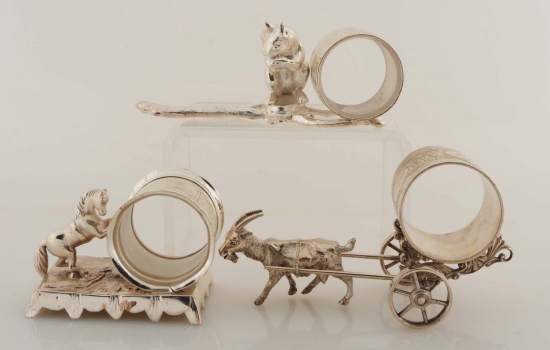 Lot of 3: Figural Napkin Rings.: Lot contains: Napkin ring of small rearing horse with front hooves on napkin holder. On a fancy raised rectangular base. 'No. 164' on base. Was also replated a while ago. A goat pulling a napkin holde
