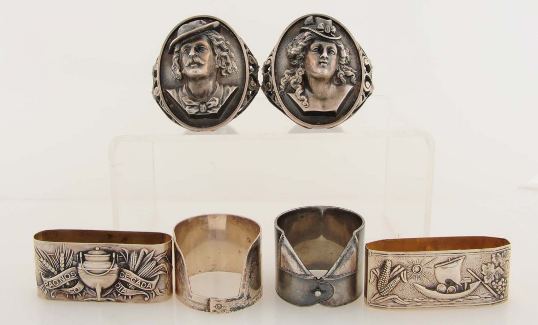 Lot of 6: Figural Napkin Rings: First napkin ring is a heavily embossed napkin ring of a man with long hair, wearing a hat and bow tie. On the back is engraved the name 'Annie'. Second napkin ring is heavily embossed with a lady wit