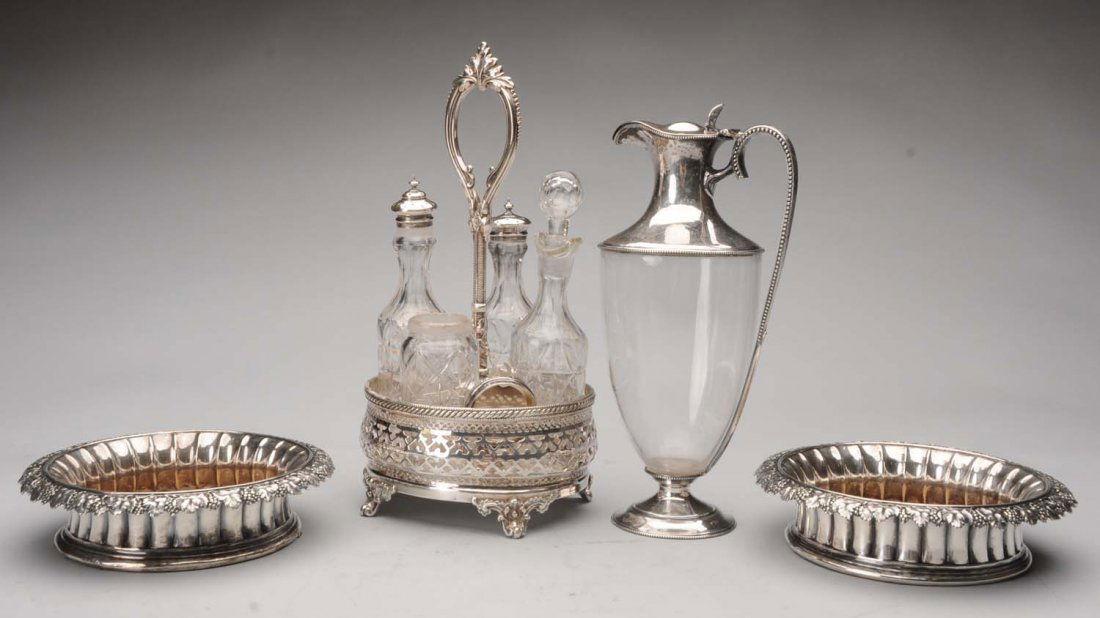 A Pair of English Silver Bottle Coasters.: Marks worn probably early 19thC, each with ribbed sides and a chased grapevine rim, the centers with crested buttons; together with an English plated four-bottle cruet with pierced sides holding a set