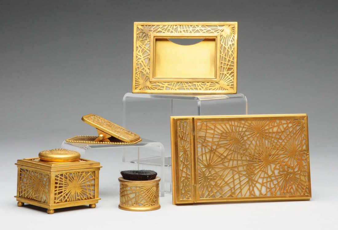 Tiffany Studios Pine Needle Desk Set.: Notepad with monogram "GAC" No. 1022, inkwell No. 845, small frame No. 941, paper clip No. 971, pen wipe with original brush No. 981. The inkwell glass is broken and there is wear to the gold. Conditi