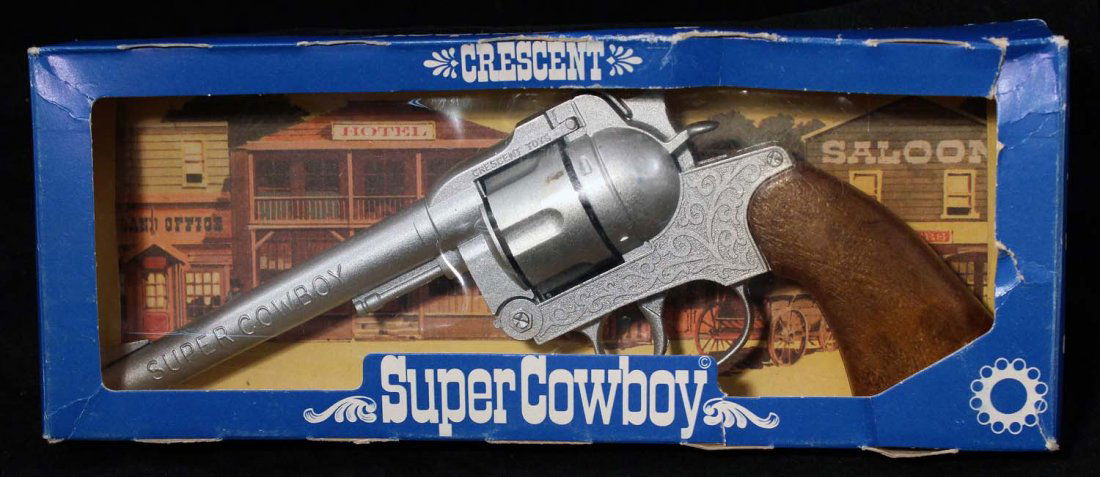 Super Cowboy Cap Pistol.: In box, circa 1970s, Crescent, England. Diecast metal with faux wood grips. Unfired. Condition (C8 Excellent - C9 Near Mint). Size 10 - 1/4" L.