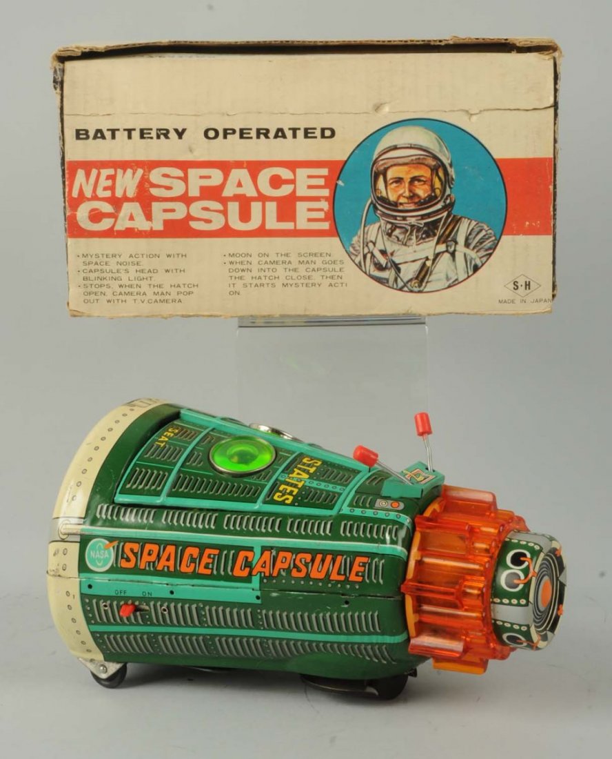 Japanese Tin Litho Space Capsule Toy.: The toy includes the original box, which is marked "S.H. Japan". The box lid is detached but present. The toy is a combination of tin litho and plastic, with a nice green color, and some overall wear.