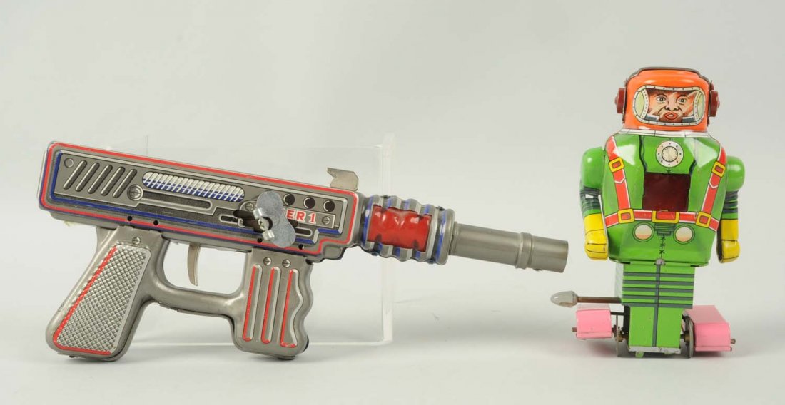Lot of 2: Japanese Tin Litho Space Items.: The first toy is a wind-up Super 1 space gun, and the second is a wind-up tin litho friction robot with roller feet. The robot has nice coloring, no longer has its attached key, and is marked "S.Y. Ma