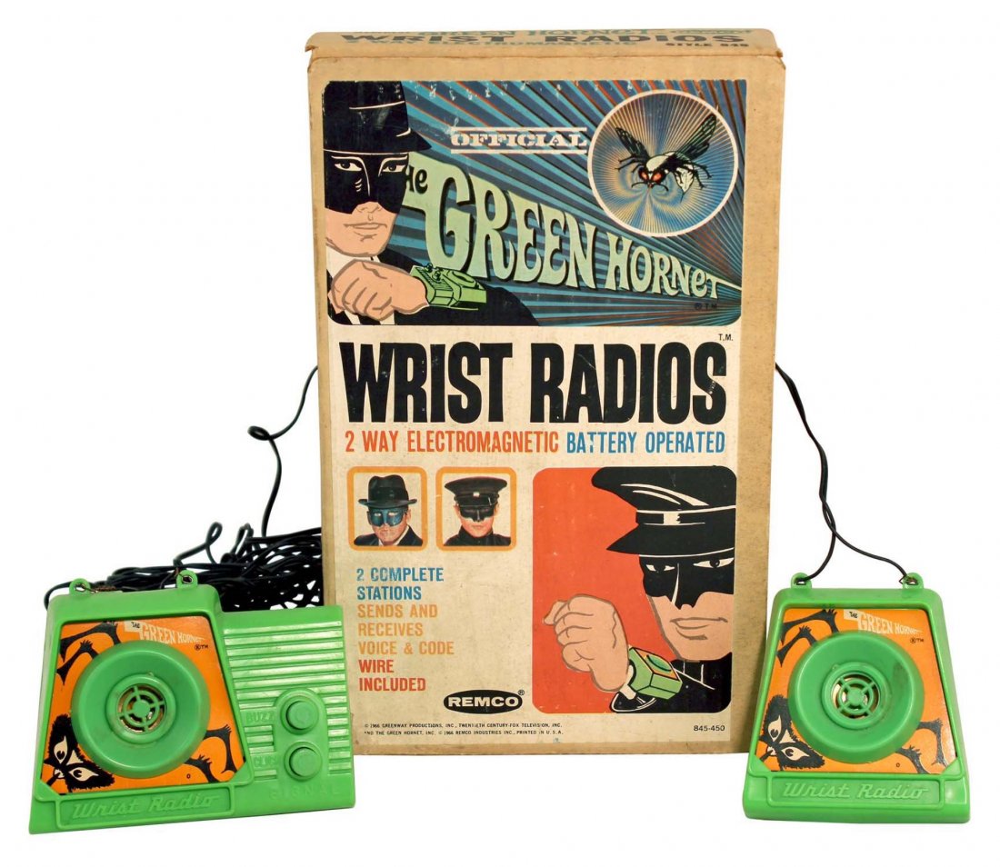 Official Green Hornet Wrist Radios.: In box, circa 1966, Remco. Contains two plastic two-way electromagnetic battery operated units with connecting wire; light stains on speakers of both units, wire is kinked; in excellent condition in c