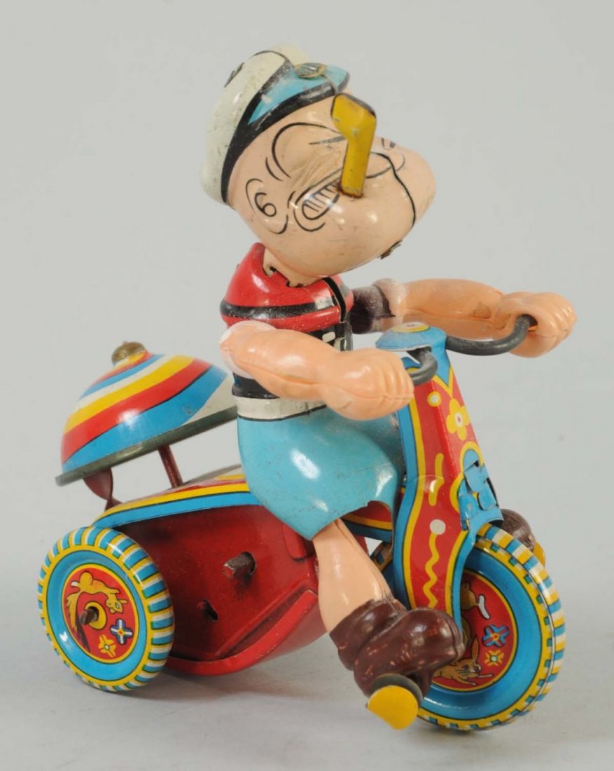 Japanese Tin Litho Wind-Up Popeye Cyclist Toy.: Marked "King Features Syndicate" and "Linemar Japan" on the rear of the toy. Includes original bell, celluloid arms look to be original, as well as the tin litho pipe. Minor scratching and wear.