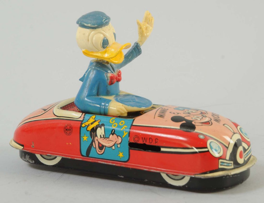Marx Donald Duck Wind-Up Mechanical Tin Car.: Donald Duck is the driver with a wiggling hat. A few visible scratches towards the bottom. Otherwise the toy is clean. Beautiful graphics of Mickey and Minnie on the hood of the car, and