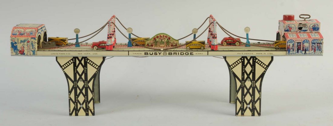 Marx Tin Wind-Up Busy Bridge Toy.: Toy has some visible scratches, and a dent towards the top of the toy around the wind-up mechanism. Otherwise, no visible scratches towards the litho. Includes six tin toy cars and road signs.