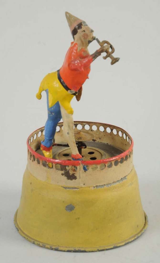 Tin Wind-Up Tin Man with Horn.: There is some paint chips throughout the toy, and the wind-up mechanism is in working condition. The man has very nice blue, yellow, and red colors. On the lower part of one of his legs, an