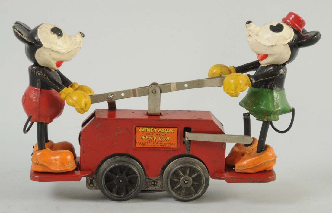 Lionel Tin Mickey Mouse Hand Car.: Car is red in color. Some significant paint scratches throughout entire toy. Some minor discoloration to Mickey Mouse and Minnie Mouse. Includes reproduction box.