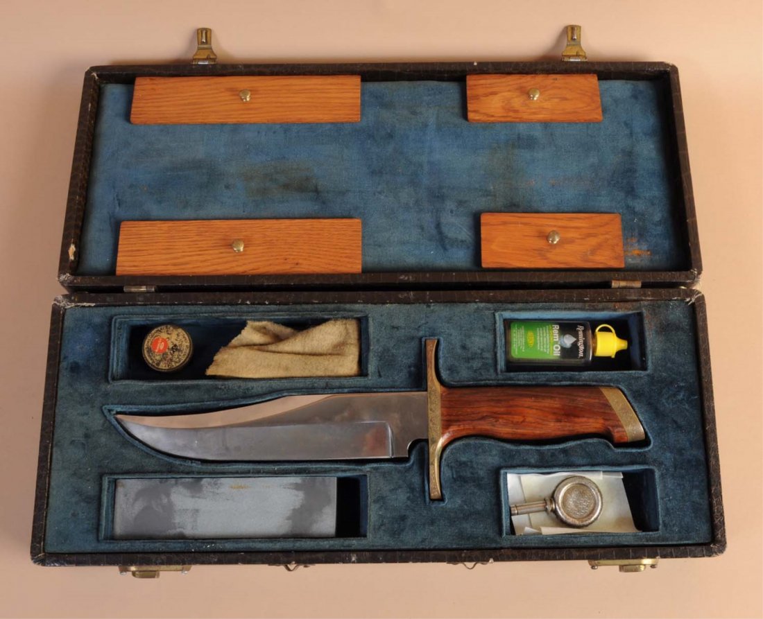 Cased Bowie Knife Replica.: A massive bowie knife replica with a blade measuring 9-1/4", 15-1/2" overall length. Handles are hard wood with nicely engraved brass guard and mounts. No sheath is included. Knife and accessories are