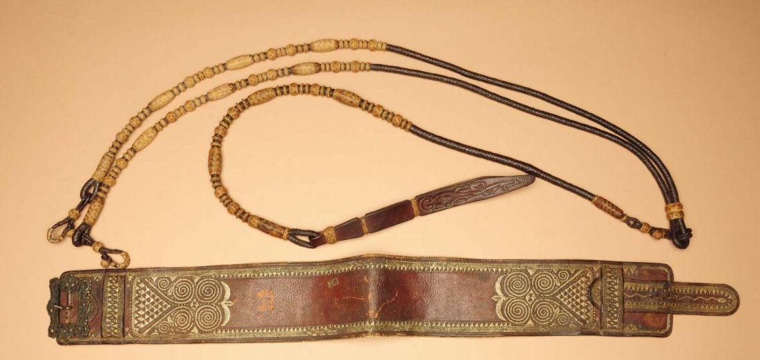 Lot of 2: Leather.: One Spanish colonial embroidered belt and one pair of braided rawhide reins with small tooled leather quirt. Condition (Good - Excellent). Size Largest: 96" L.