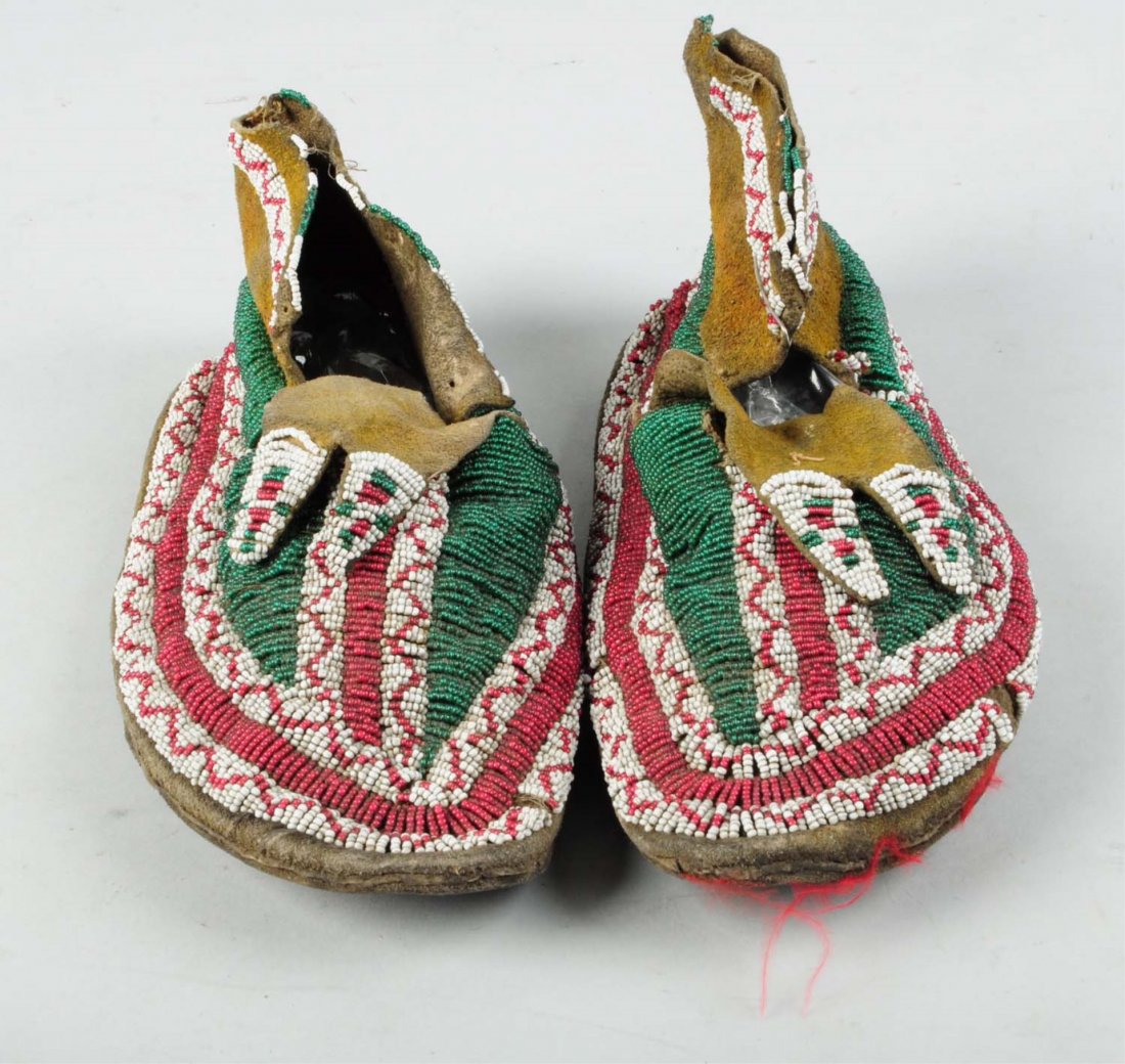 Northern Plains 19th Century Beaded Moccasins.: Brain tan leather. Stiff, with some loss to the beadwork. 800-1000 Condition (Fair). Size 11" L.