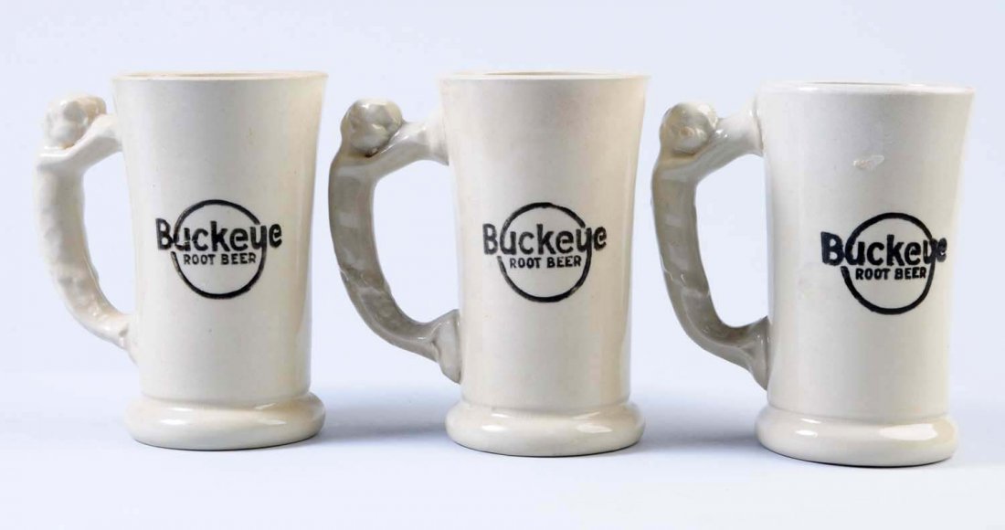 Lot of 3: Tall Buckeye Root Beer Mugs.: All three mugs have the figural handle. Some light crazing here and there. Overall very nice. Condition (Excellent). Size Each: 6" T.