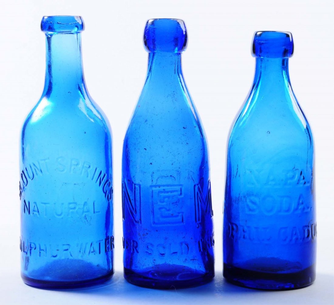 Lot of 3: Early Bottles.: This lot includes: a blue Blount Springs Sulphur water bottle, a blue M. Keane bottle and a blue Napa soda Phil Caduc mineral water bottle. The Keane bottle has some contact wear. Condition (Very Good