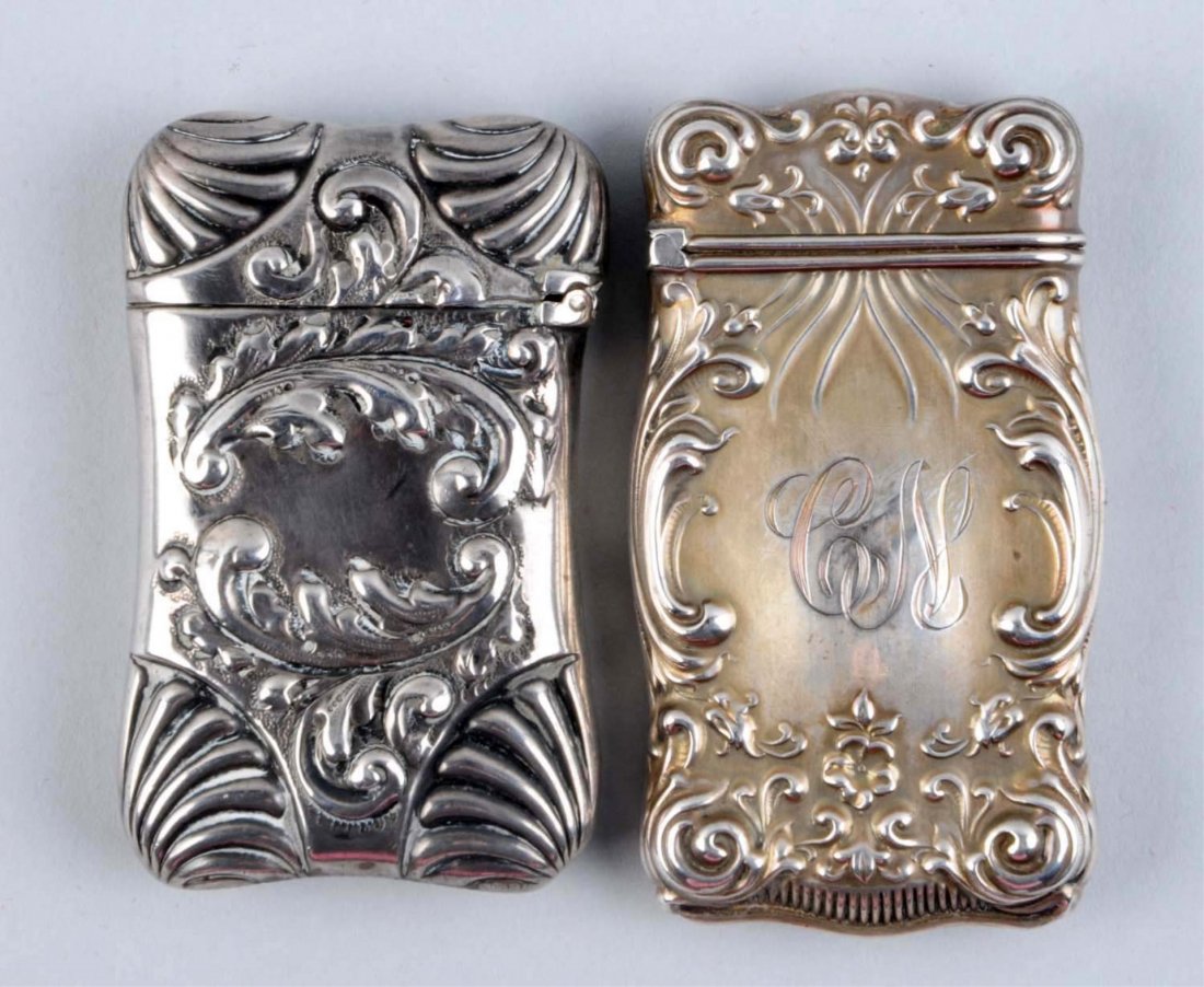 Lot of 2: Sterling Silver Match Safe Vestas.: One with a scroll motif, and the other with a flower motif. Strong hinges. No dents. Condition (Excellent). Size Each: 2 - 1/2" L.