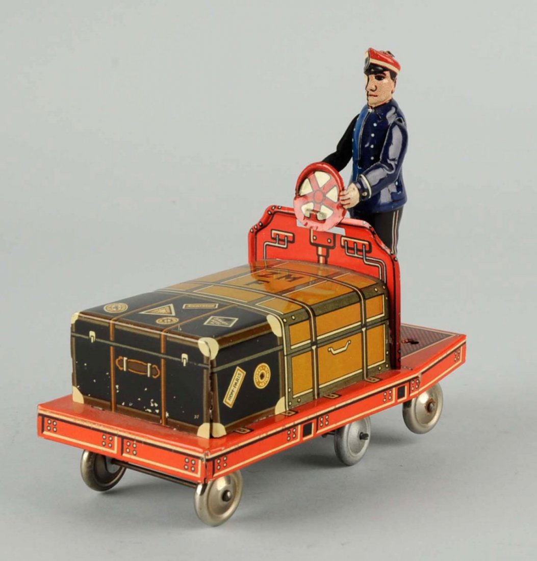 Tin Wind-Up Porter Toy.: Made in U.S. zone in Germany. Includes the cart and its tin rider. There are very slight scratches to the litho, mainly to the luggage. Otherwise, the toy is very clean. In working condition. Conditio