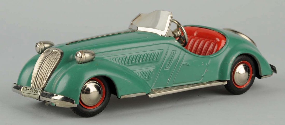 Tin Wind-Up Car.: Made in U.S. zone in Germany. There are some paint scratches throughout the car. Plastic windshield is twisted but present. On/Off button for wind-up mechanism is the stick shift for the car. Conditio