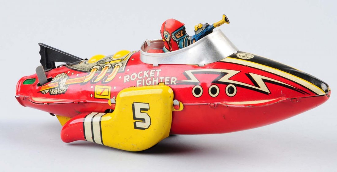 Marx Tin Wind - Up Rocket Fighter Space Toy.: Tin pilot holding machine gun. Has some litho scratches throughout toy. Otherwise colors are still stunning and bright. Toy includes original wind - up key. Condition (Very Good - Excellent). Size 12 