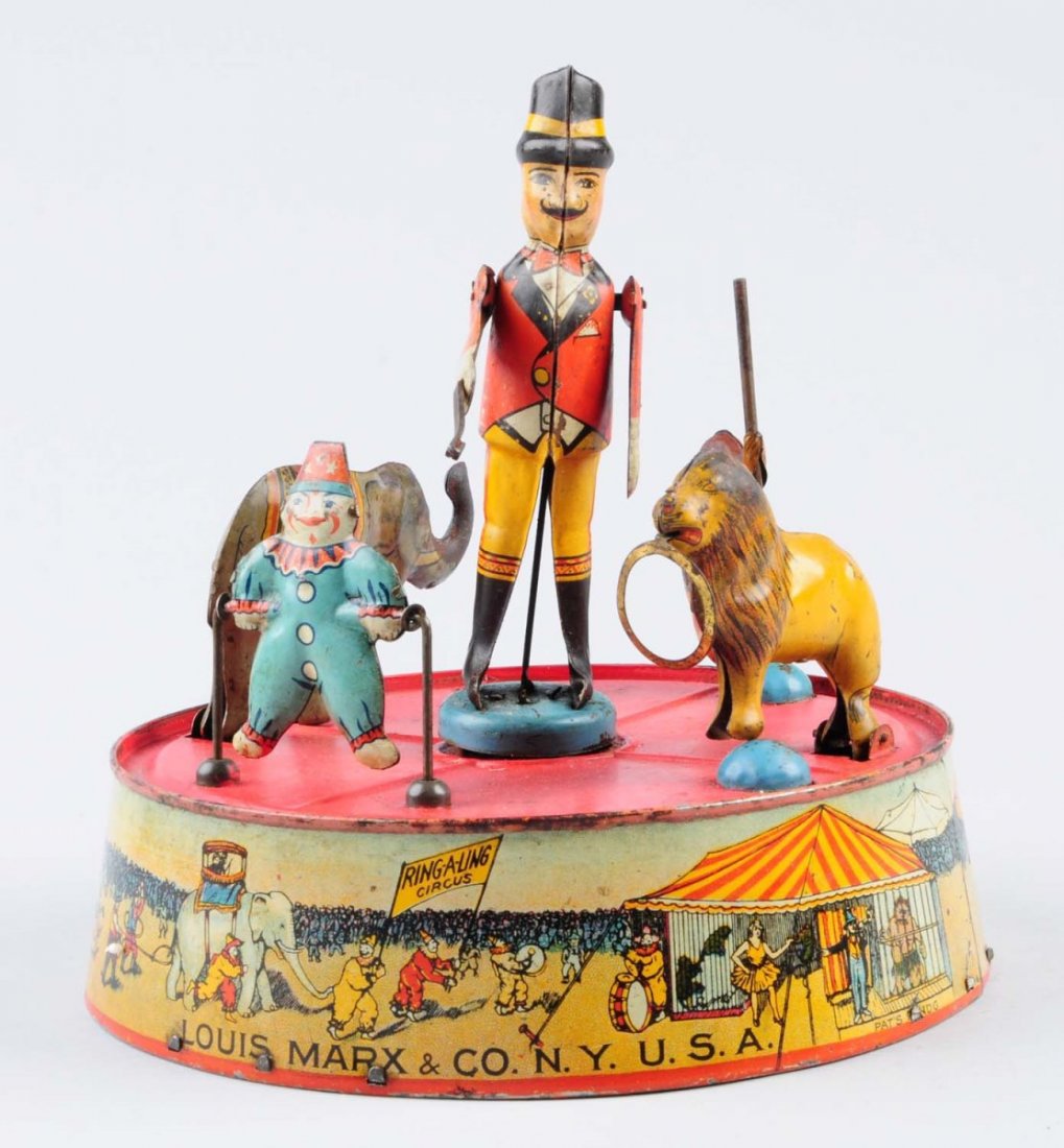 Marx Tin Wing - Up Ring - a - Ling Circus.: Toy has significant litho scratches and chips throughout. Remaining litho colors on toy has graphics of circus actors and circus clowns playing around the circus grounds. Condition (Good - Very Good).