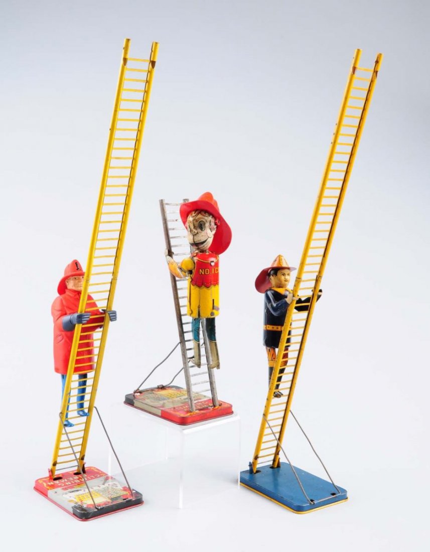 Lot of 3: Tin Wind - Up Climbing Fireman.: Two of the firemen are made from tin, the other one is made of plastic. piece is missing from one of the ladders and the other two are complete. Couple of the toys have some scratched and loss through