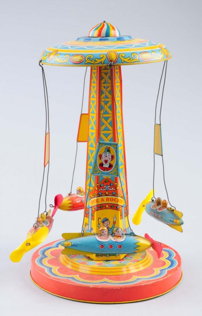 Tin Wind - Up Ride a Rocket Toy.: The toy has some litho scratches and loss throughout but mainly to roof of toy and around base. Some spots of oxidation on the tin rockets. Marked "Ride a Rocket". Comes with four rockets and each has