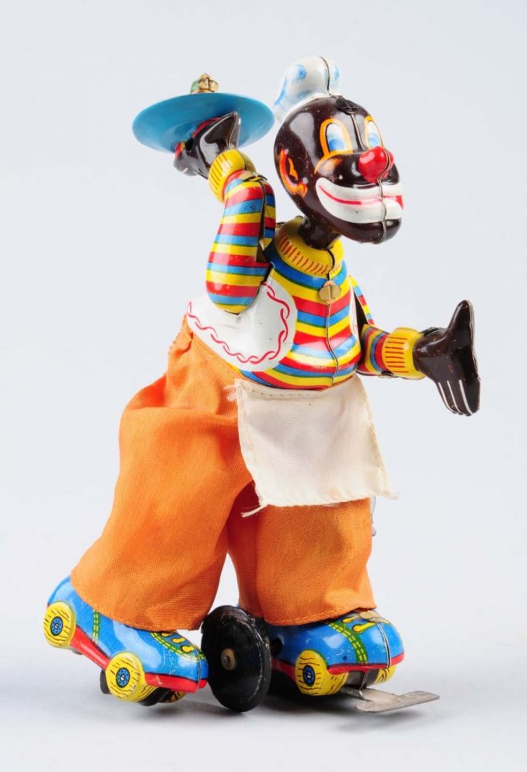 Tin Wind - Up Clown on Skates.: Made in Japan. Minor scratches to litho section of the toy. Clown is wearing cloth pants and apron. Clown is carrying tin plate with vegetables on it. Beautiful colors. Includes original wind - up key